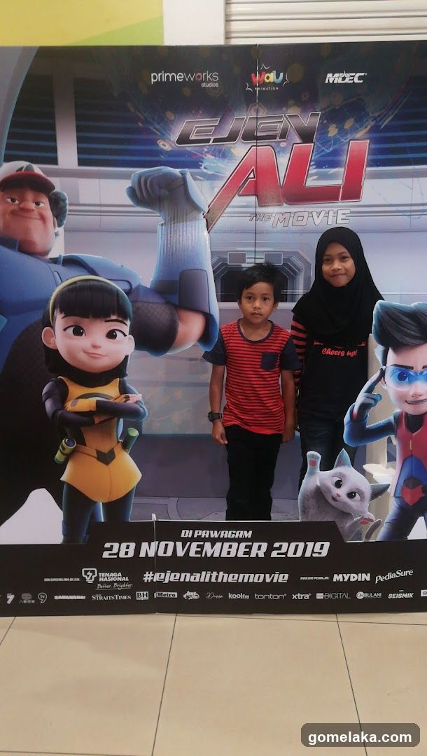 Two children posing in front of a movie poster
