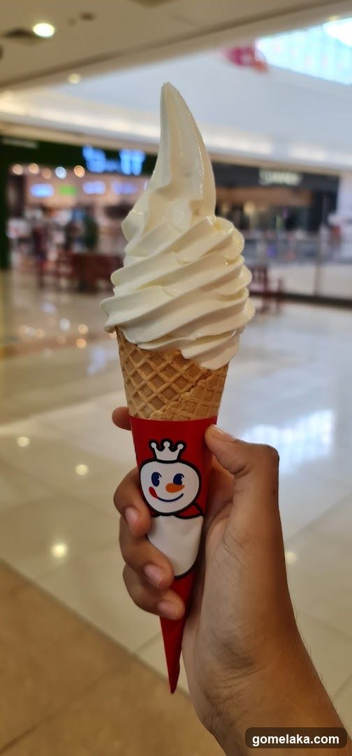 Hand holding soft serve ice cream in shopping mall