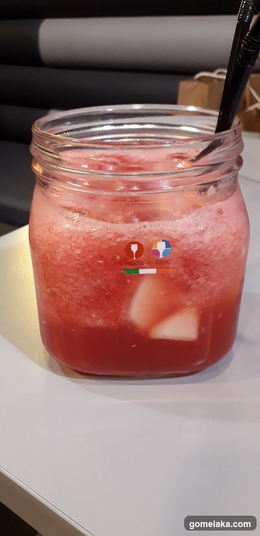 Red beverage in mason jar with straw