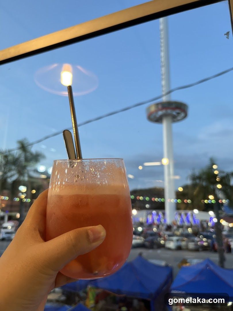 Hand holding drink with view of outdoor scene