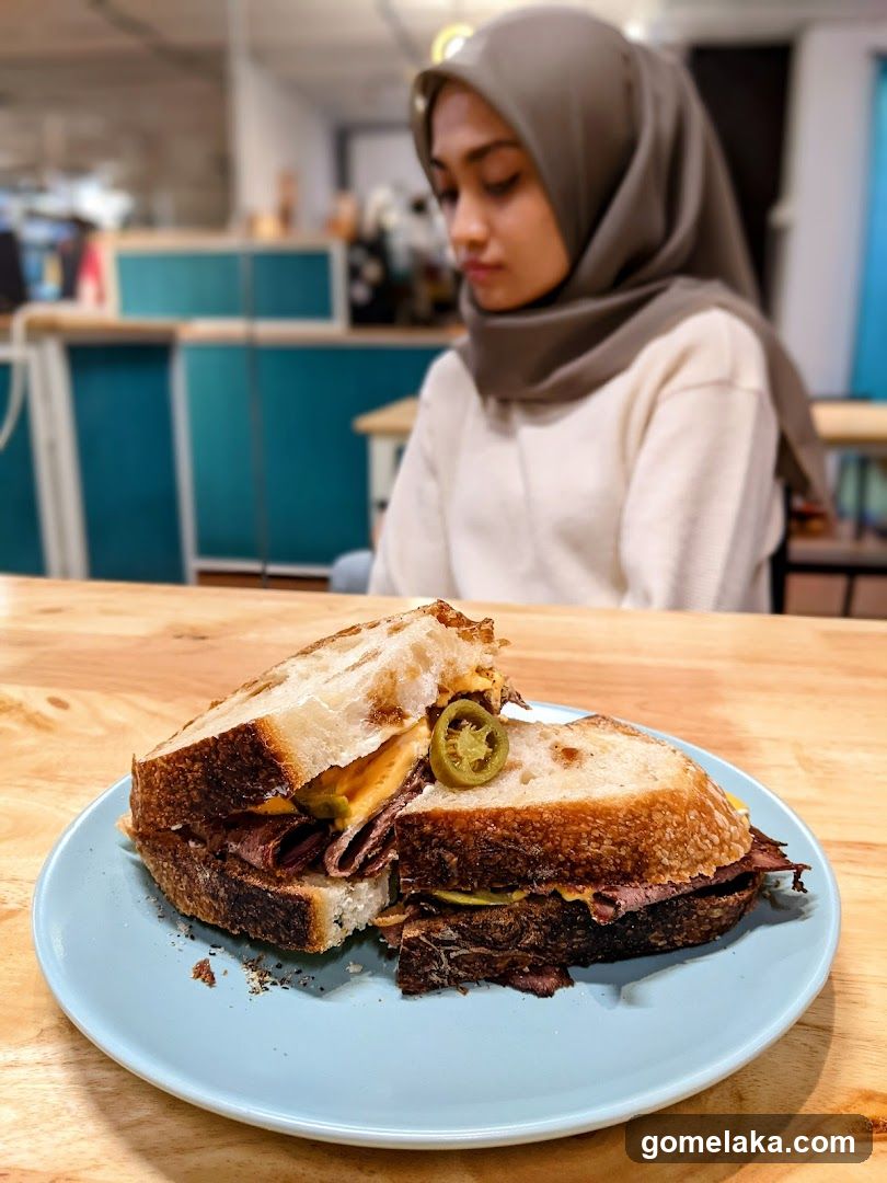 Sandwich and person in café interior