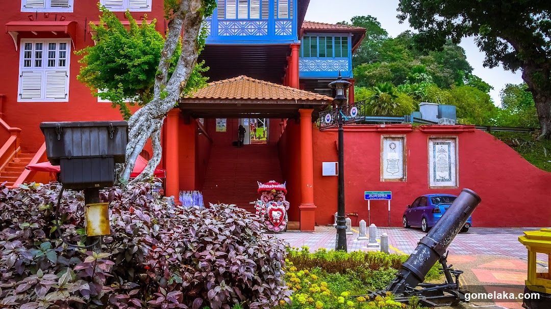 Red Building with Cannon and Greenery