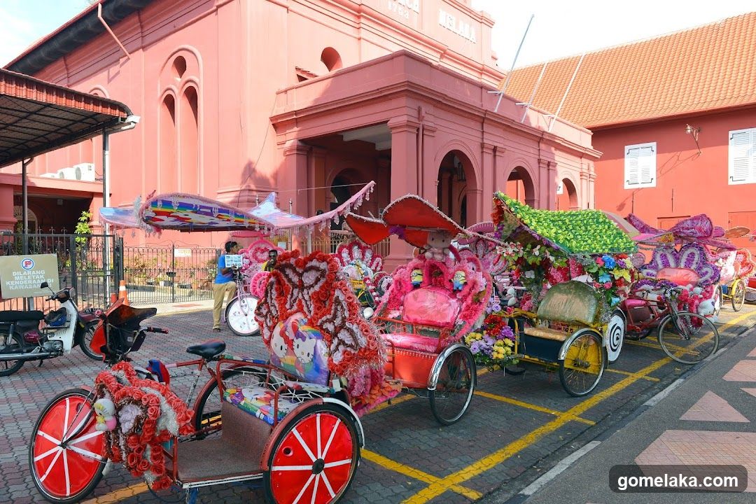 Decorated rickshaws in front of pink building