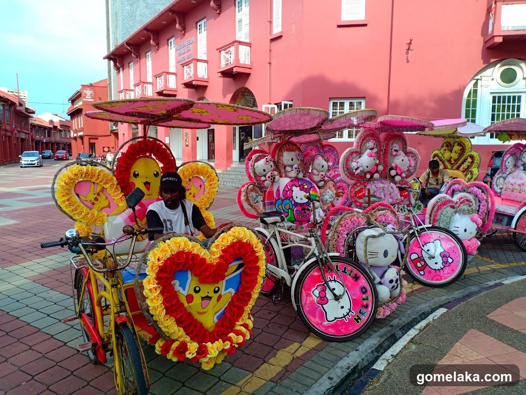 Decorated Bicycle Rides in Front of Pink Building