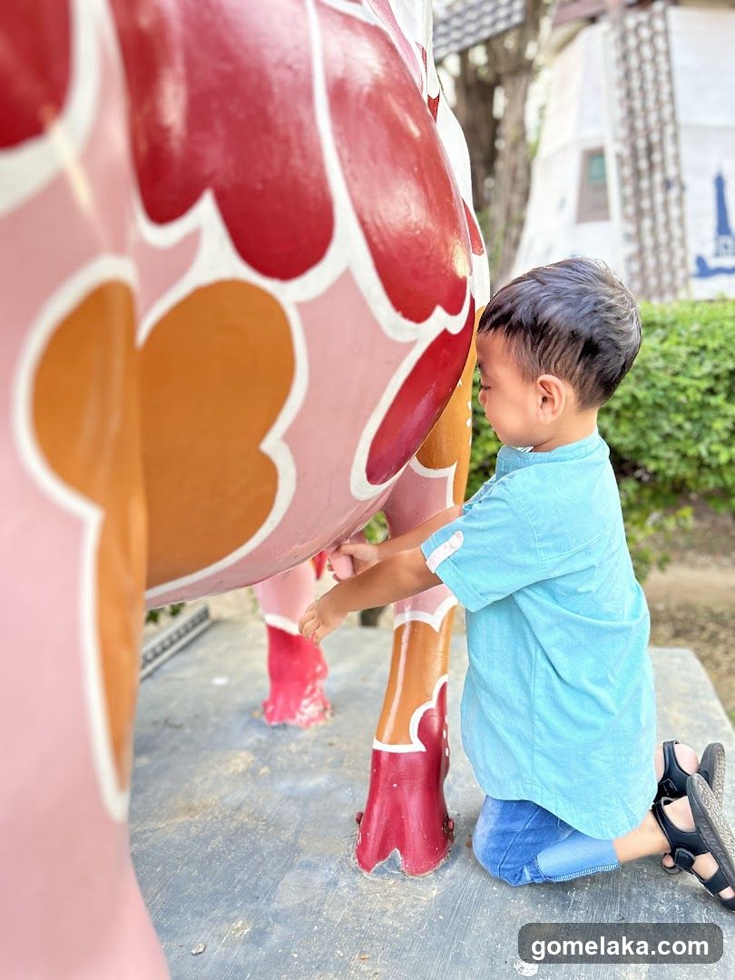 Child interacting with colorful sculpture