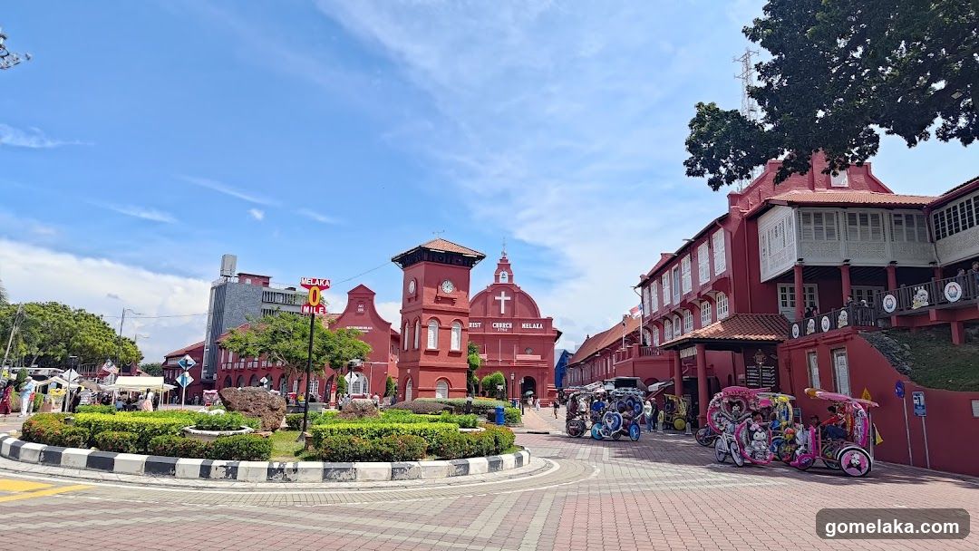 Red Building Complex with Clock Tower and Tuk-Tuks