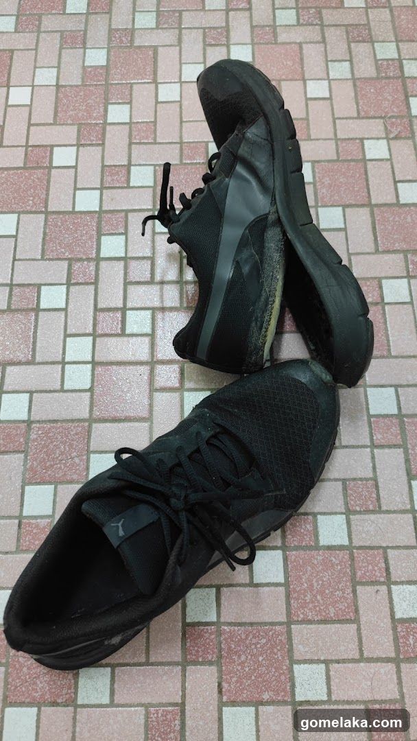 Pair of black sneakers on tiled floor