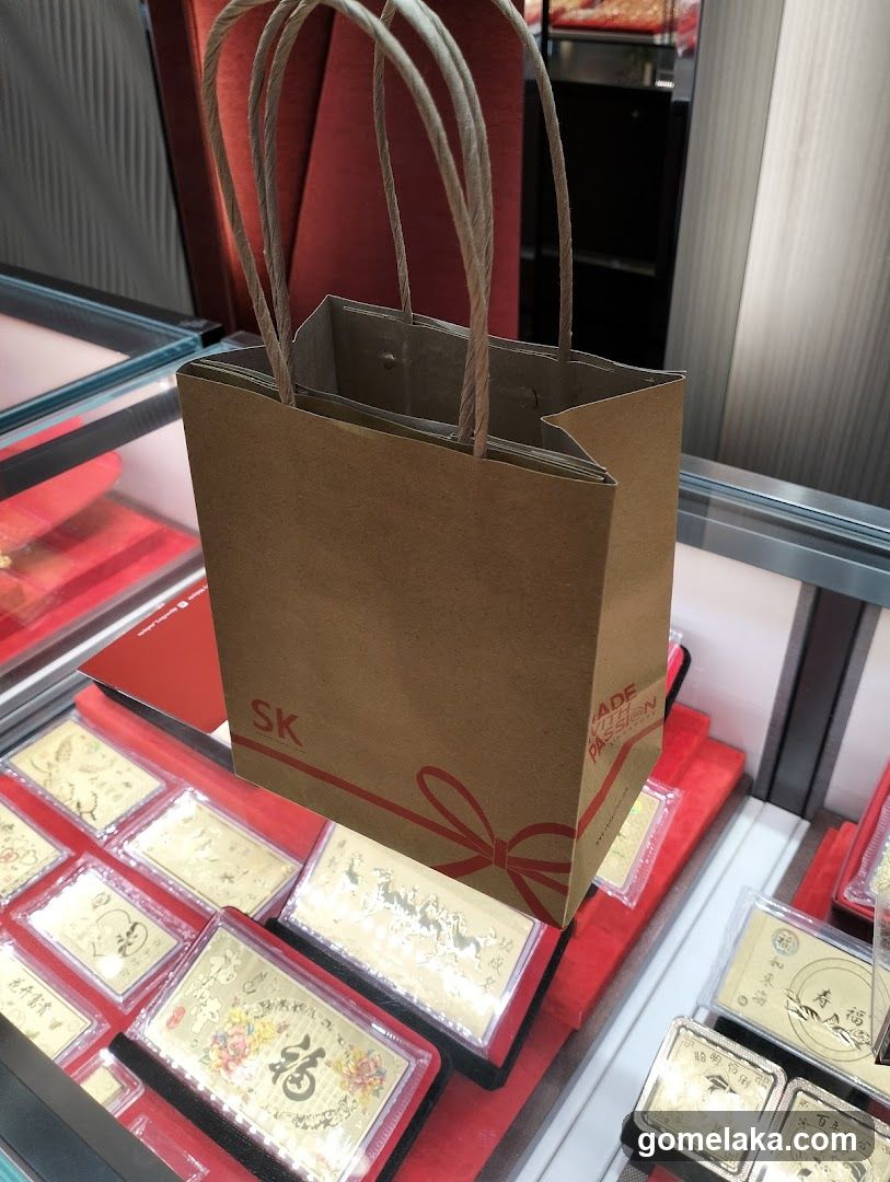 Brown paper shopping bag with SK logo