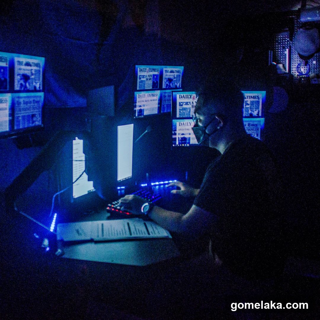 Person working in dimly lit room with multiple monitors