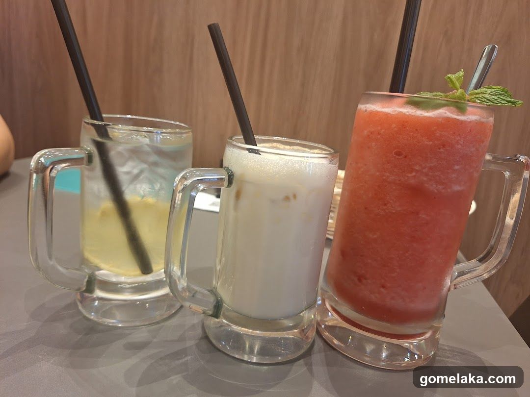 Three beverages in mugs with straws