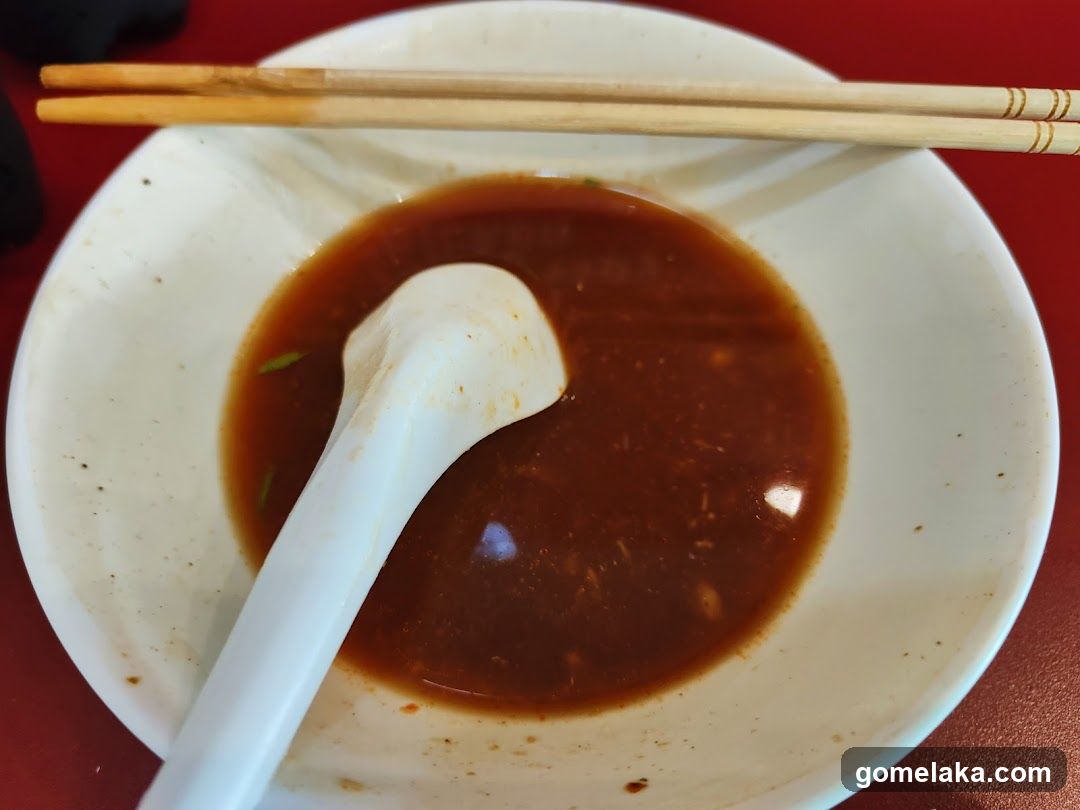 Bowl of soup with chopsticks and spoon