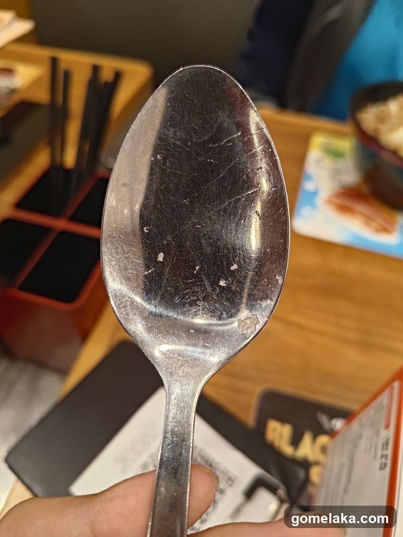 Hand holding spoon in restaurant setting