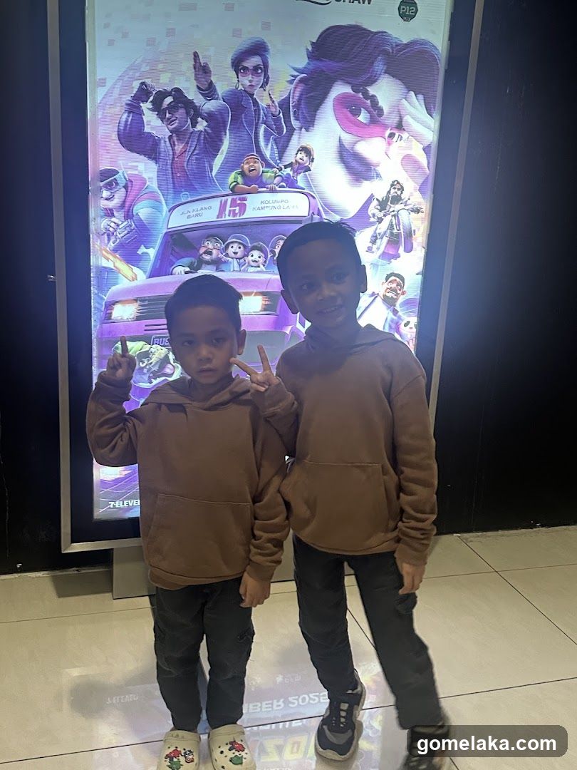 Two children posing in front of a movie poster