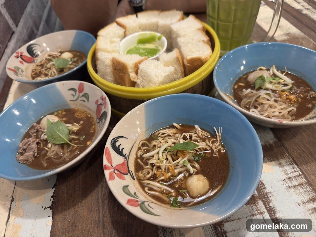 Table with Thai-style noodle dishes and bread