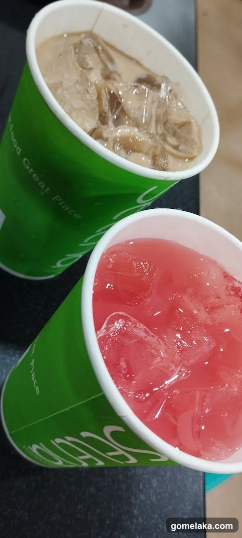 Two beverages in green paper cups