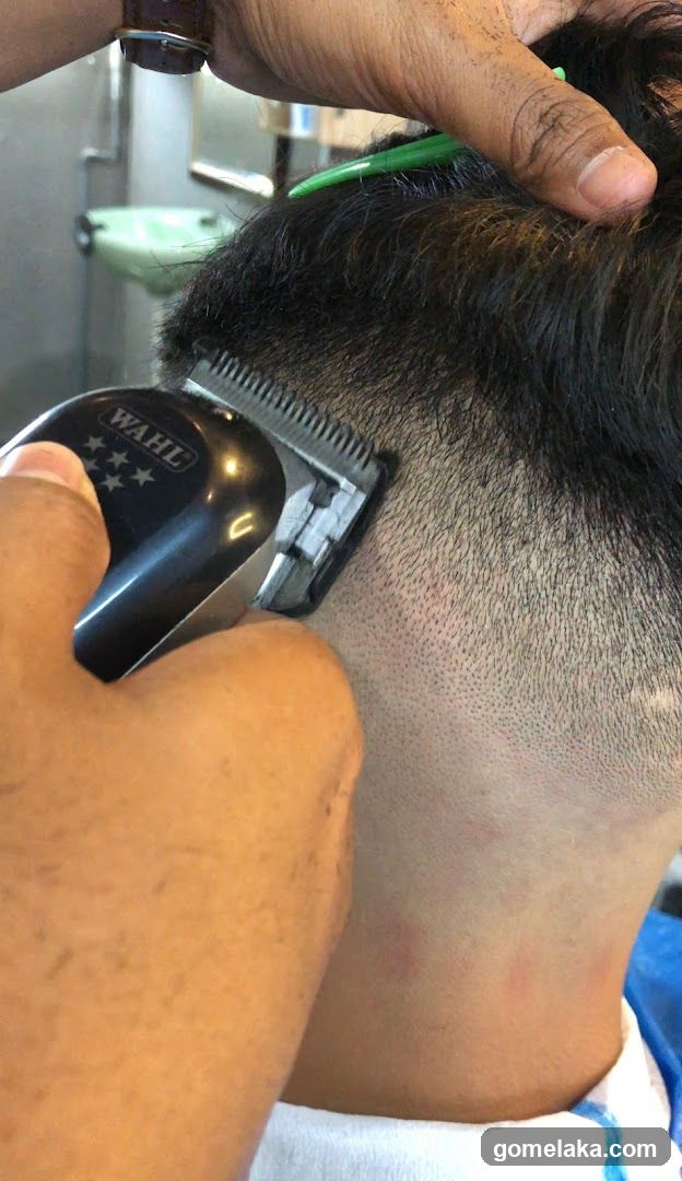 Barber cutting hair with electric clipper