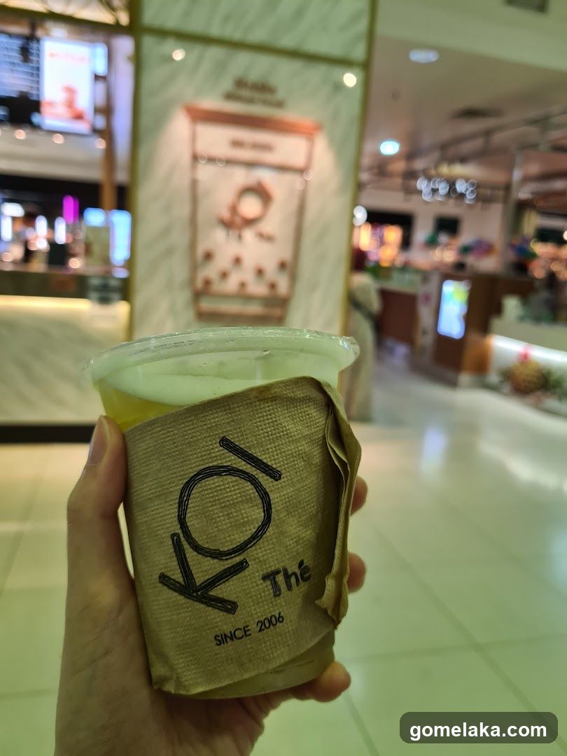 Hand holding beverage cup in shopping mall