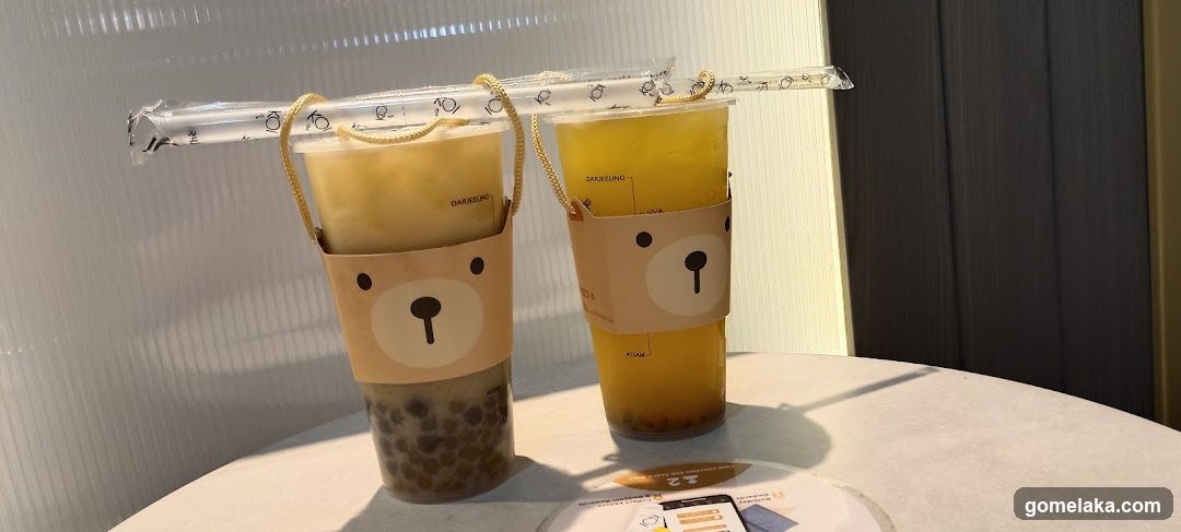 Two bubble tea drinks with bear-themed cups and straws