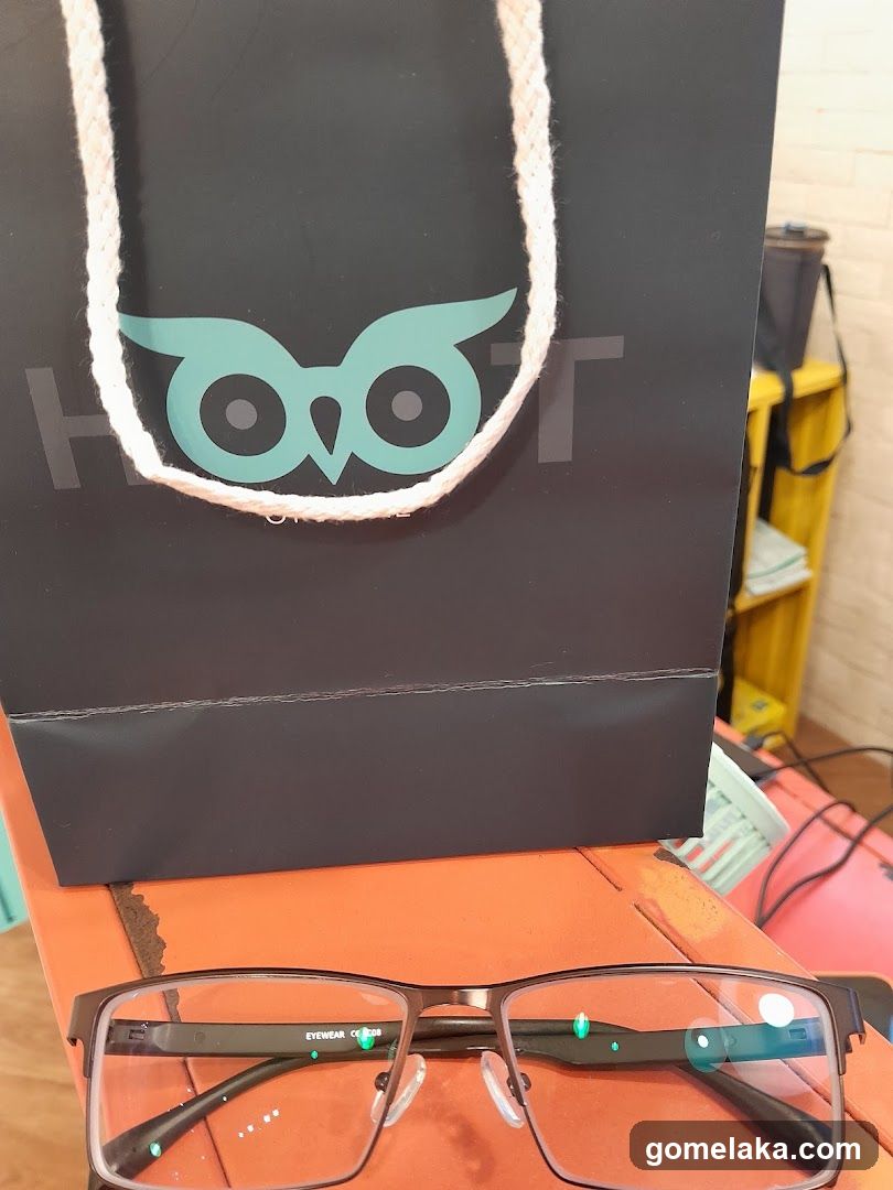 Owl-themed shopping bag and glasses on orange surface