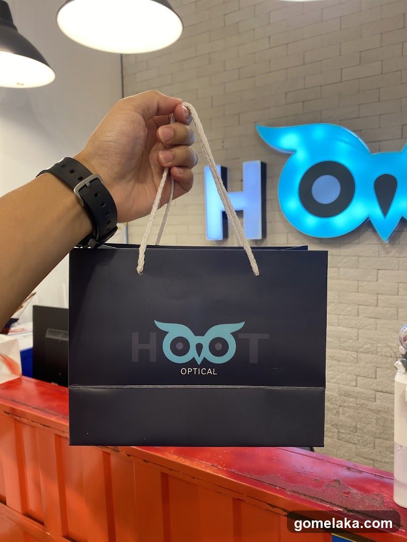 Hand holding shopping bag at optical store