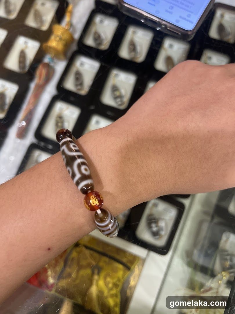 Hand wearing bracelet in display case