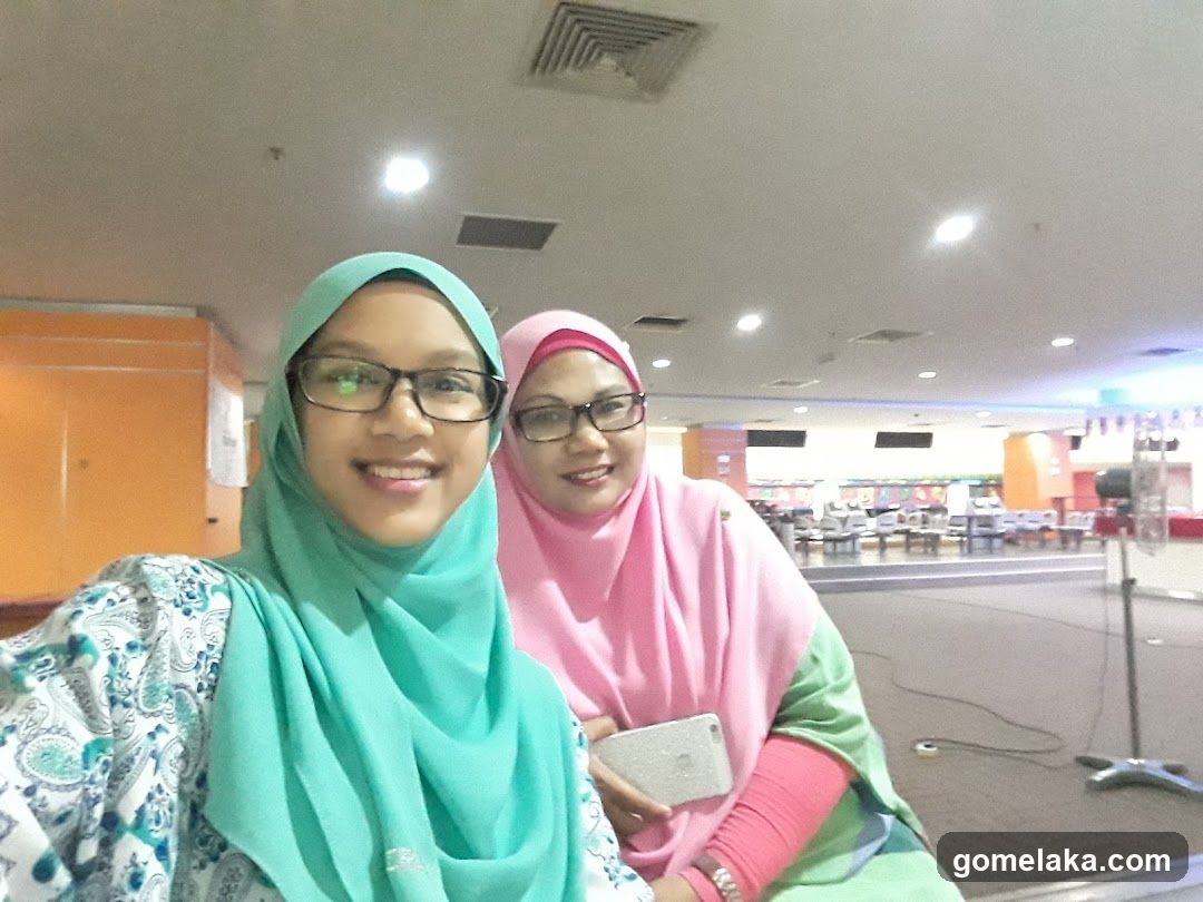 Two women in hijabs taking selfie indoors