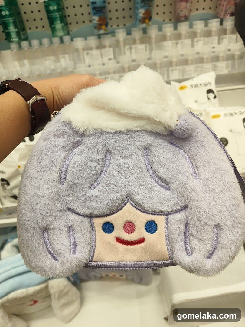 Hand holding plush character bag in store aisle