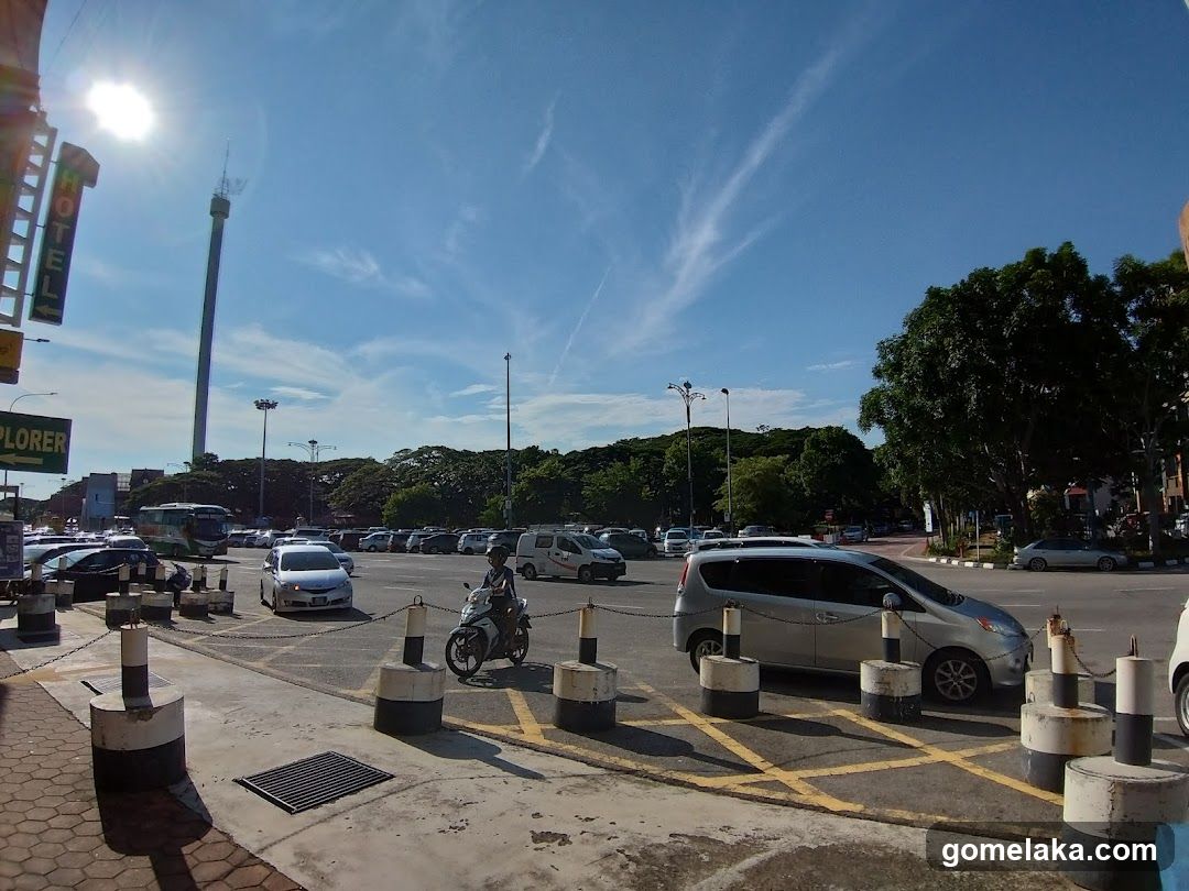 Outdoor parking area with vehicles and a tall tower