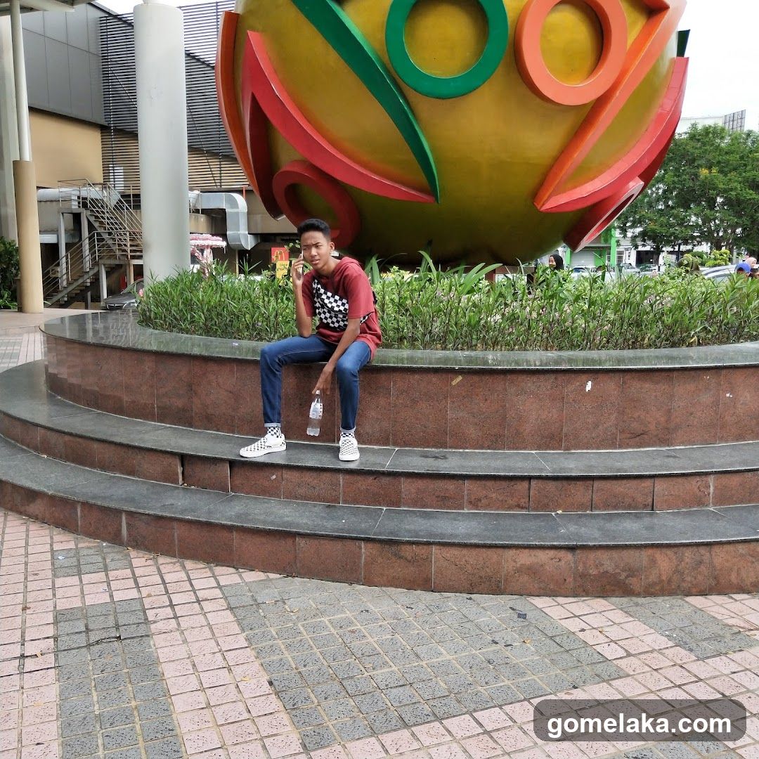 Person Sitting Near Large Sculpture