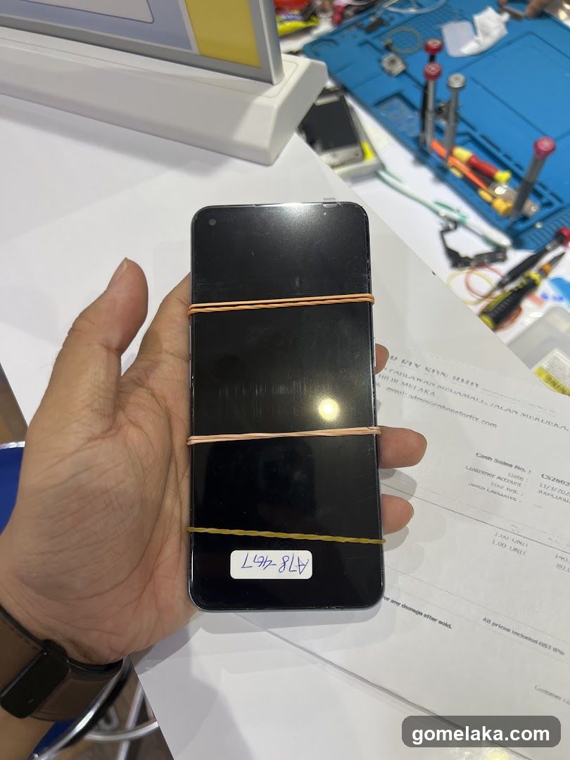 Hand holding a smartphone with rubber bands and label