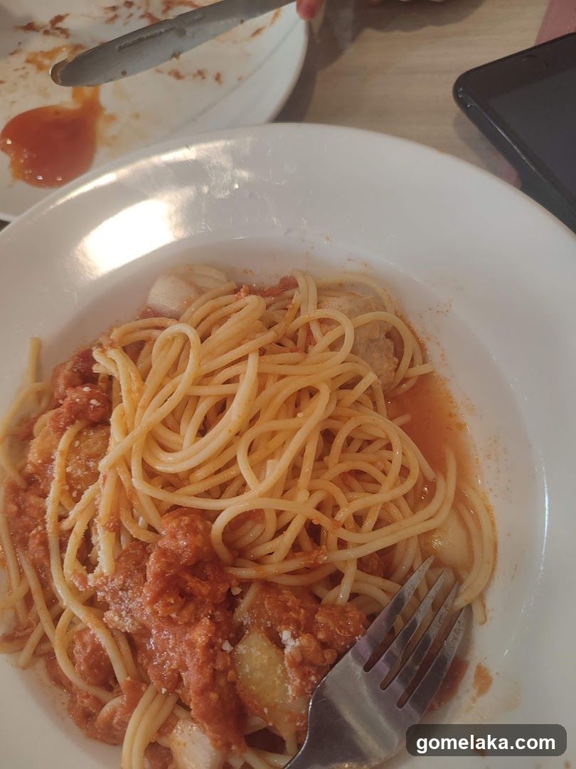 Spaghetti dish with tomato sauce and fork on plate