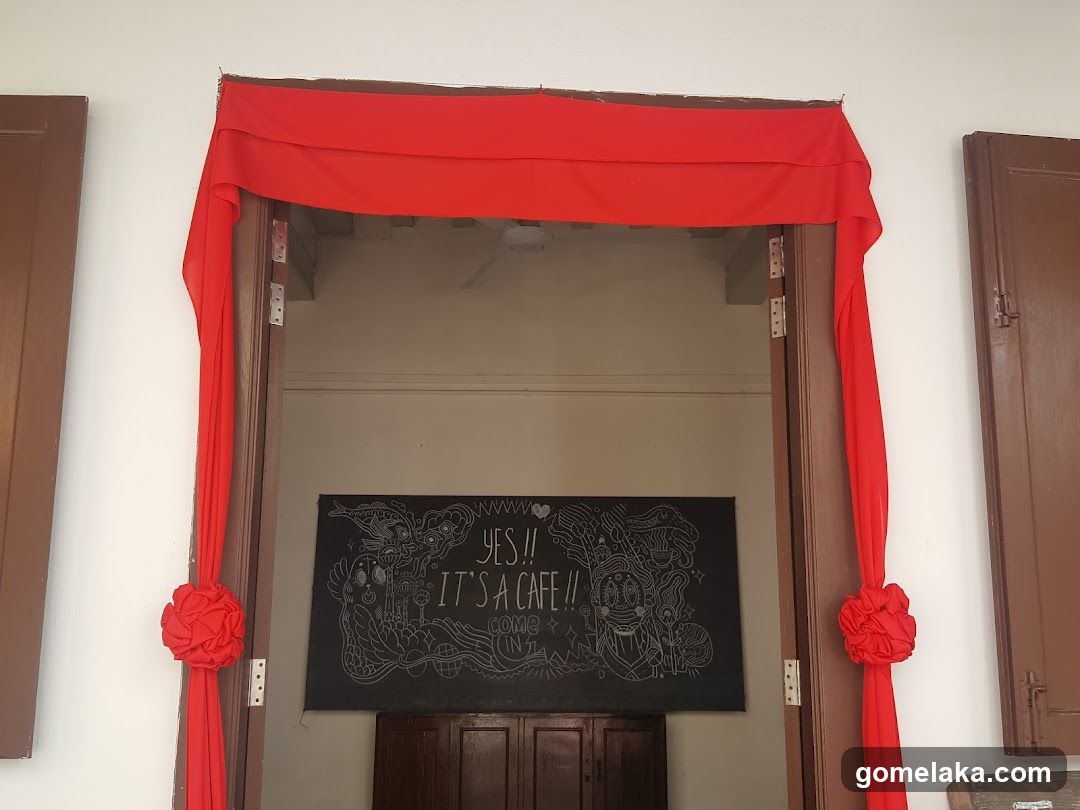 Interior entrance with red drapes and chalkboard sign