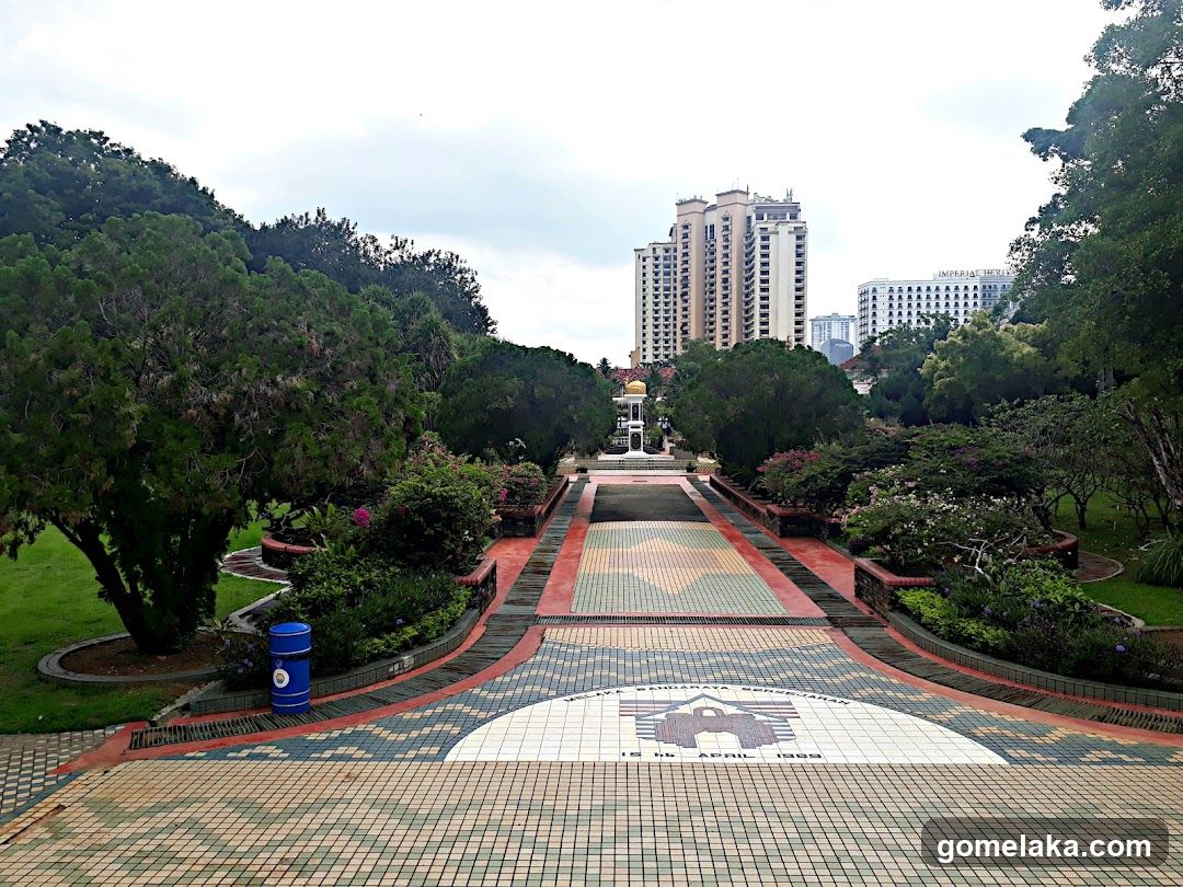 Park Pathway with Monument and Urban Background