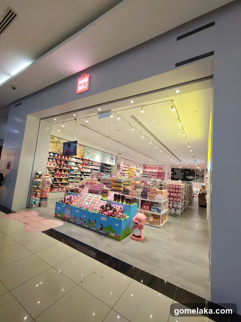 Storefront with illuminated red MINI SOF logo above glass entrance. Interior visible, brightly lit with shelves of products and pink-themed displays. Pink plush toy on floor near entrance.